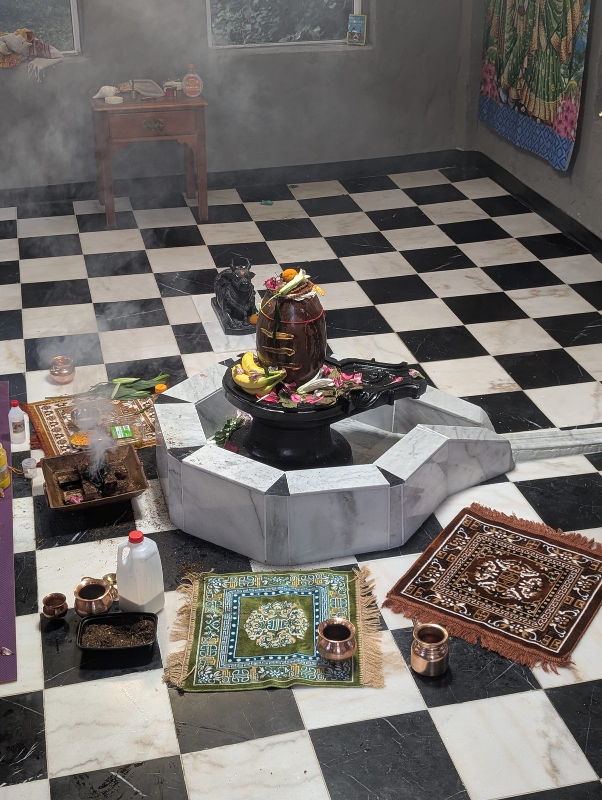 The fire ceremony (yagya) burning in the shrine room, with the offerings laid out